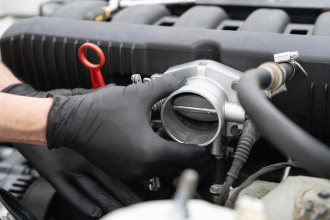 Mécanicien inspectant une pièce moteur à proximité de l'emplacement du catalyseur pour Citroën Berlingo