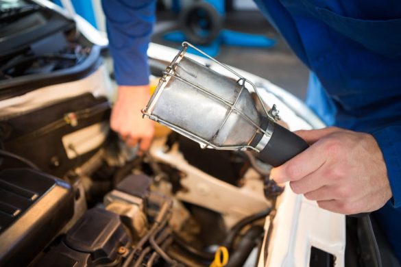 Technicien éclairant le compartiment moteur pour localiser le catalyseur pour Citroën Berlingo