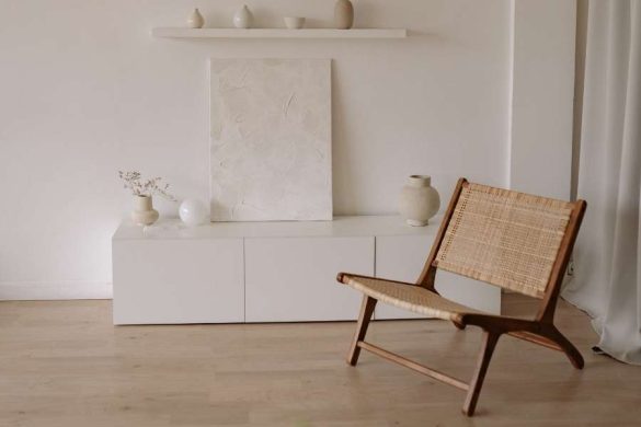 Fauteuil en bois et cannage rénové dans un salon minimaliste blanc, belle illustration de comment donner une seconde vie à ses vieux meubles avec élégance.
