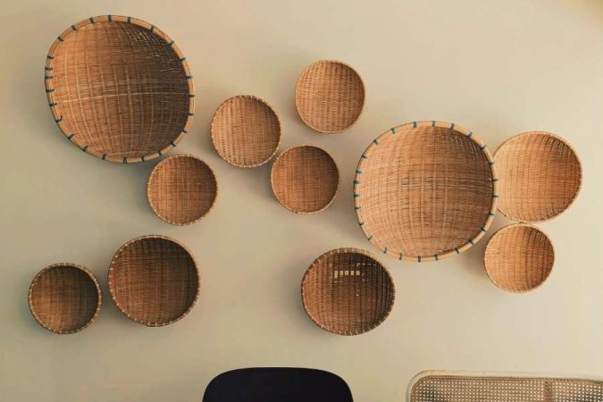 Une collection de paniers tissés de différentes tailles fixés au mur comme décoration murale originale dans un salon moderne.