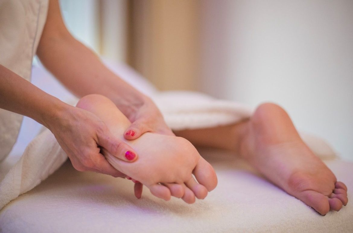 Mains massant la voûte plantaire d'un pied nu pour un massage podologique soulager fatigue pieds efficace.
